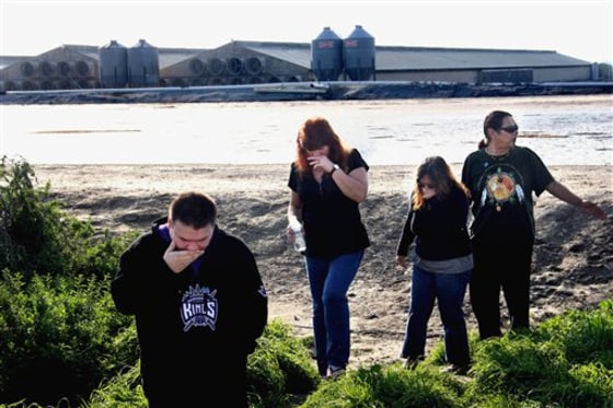 Residents of Briggs Road react to the stench from a lake of chicken excrement on Wednesday.